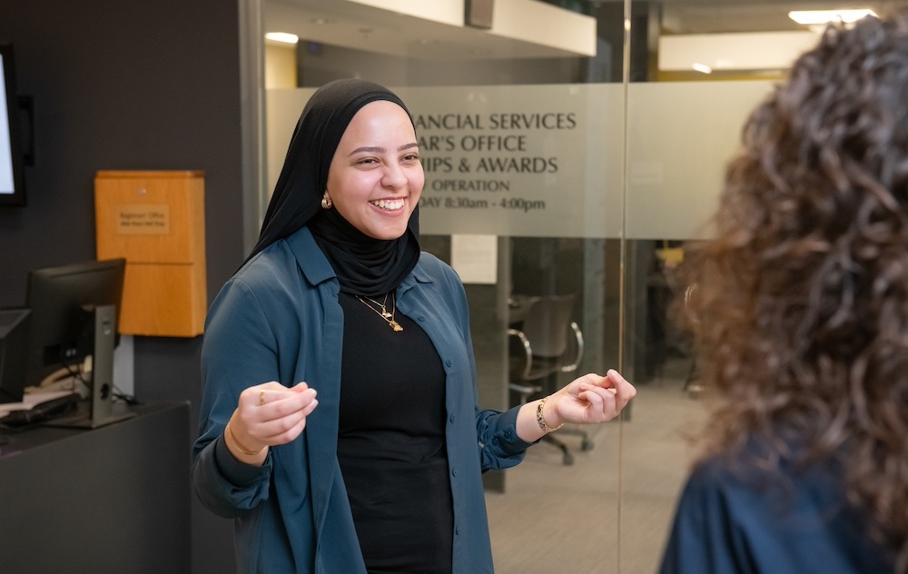 91̽ staff member Fairouz talking with a co-worker